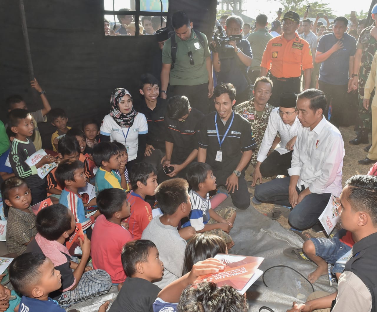 Presiden Jokowi dan Gubernur NTB Tuan Guru Bajang saat menghibur anak korban gempa (30/7). Foto : Biropers Istana