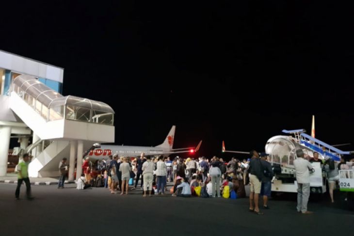 Sejumlah calon penumpang pesawat di Bandara Praya, Lombok berhamburan untuk berkumpul di landasan pacu bandara, sesaat gempa berkekuatan 7.0 SR kembali mengguncang Lombok, NTB, pada Minggu, 5 Agustus 2018 malam sekitar pukul 18:49 Wita.  (Foto: Antara)