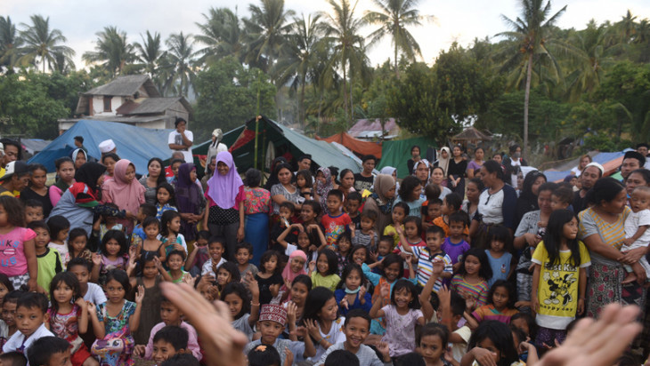 Sejumlah anak bernyanyi bersama dengan relawan di tempat penampungan pengungsi korban gempa bumi di Pemenang, Lombok Utara, Lombok Utara, NTB, Selasa 7 Agustus 2018. Sebanyak 2.935 jiwa korban gempa bumi mengungsi di tempat itu dan diperkirakan akan terus bertambah. (Foto: Antara)
