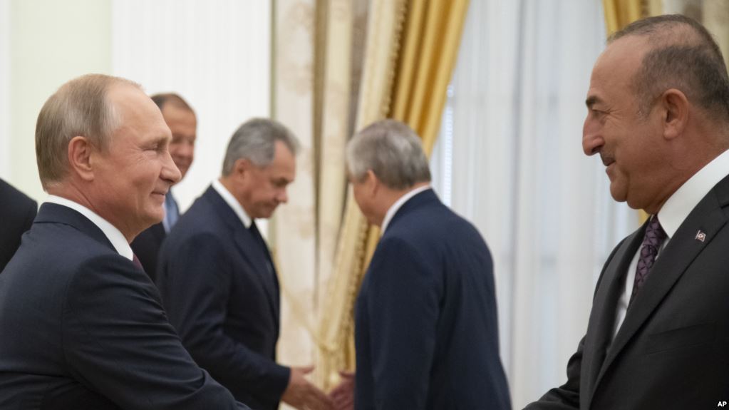 BERUNDING: Presiden Rusia Vladimir Putin (kiri) berjabat tangan dengan Menlu Turki Mevlut Cavusoglu di Kremlin, Moskow, 24 Agustus 2018. (foto: ap)