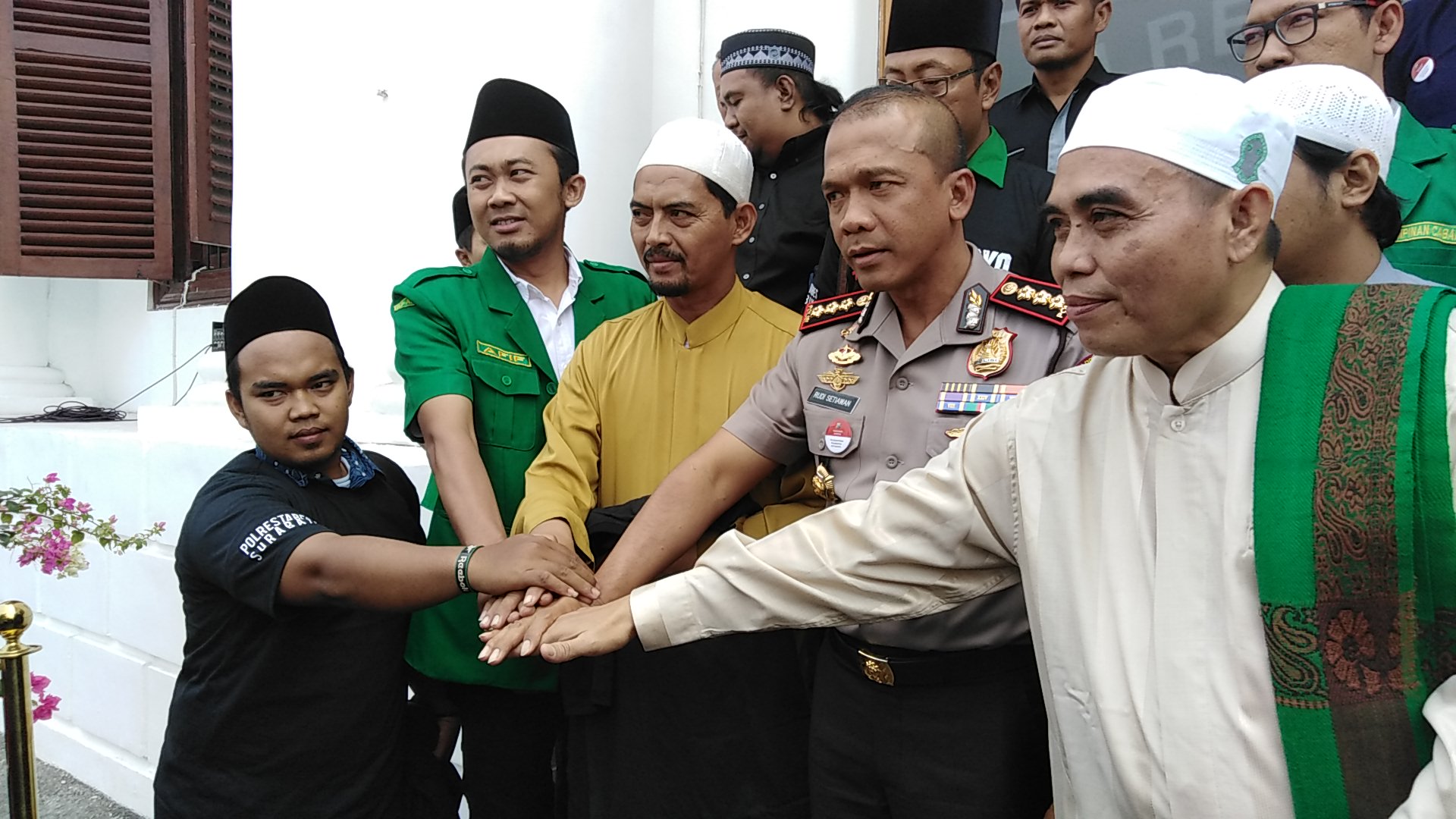 Pimpinan Banser, Front Pembela Islam dan Kapolrestabes Surabaya satukan tangan usai mediasi di Mapolrestabes Surabaya. (Foto: Farid/ngopibareng.id) 