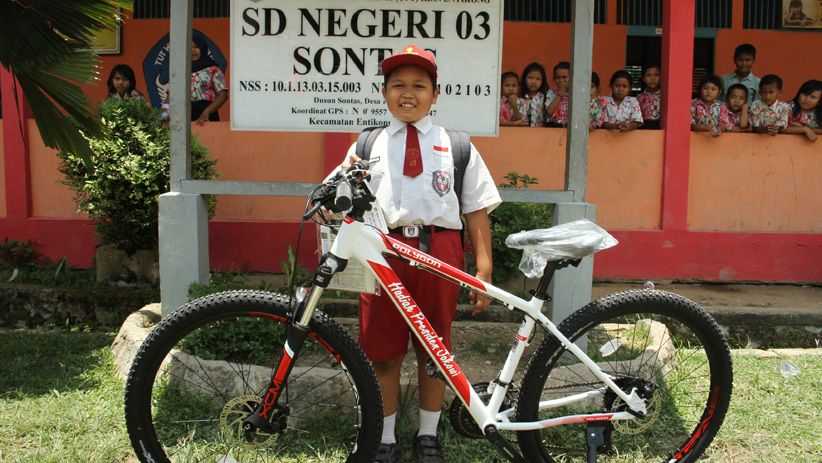 Nursaka berfoto bersama sepeda barunya di SDN 03 Sontang, Kecamatan Entikong, Kabupaten Sanggau, Kalimantan Barat, Kamis 13 September 2018. (Foto: Antara)