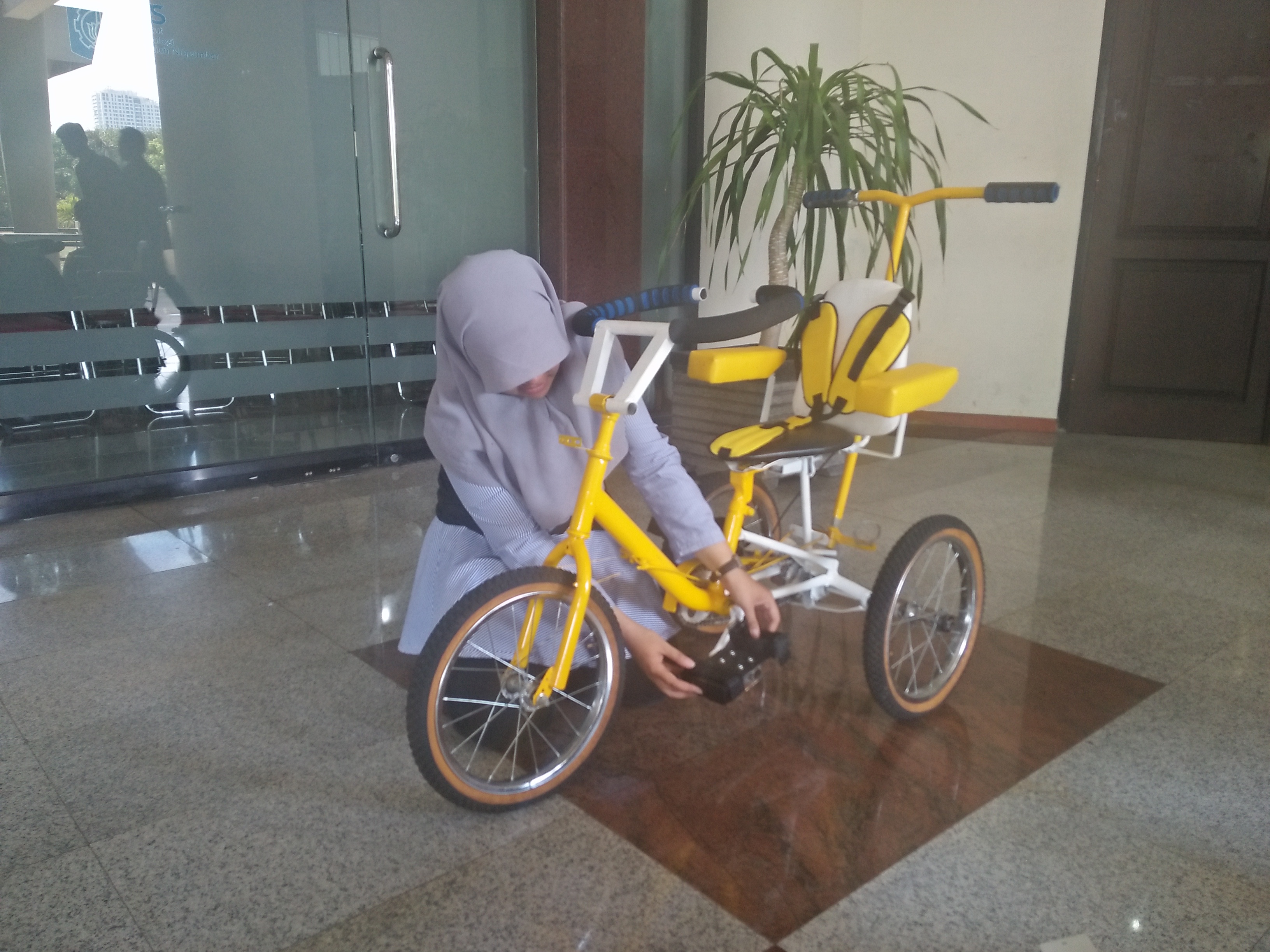 Elly Fitriana Soedjito memperlihatkan cara menggunakan sepeda desainannya. Foto: Amanah/ngopibareng.id