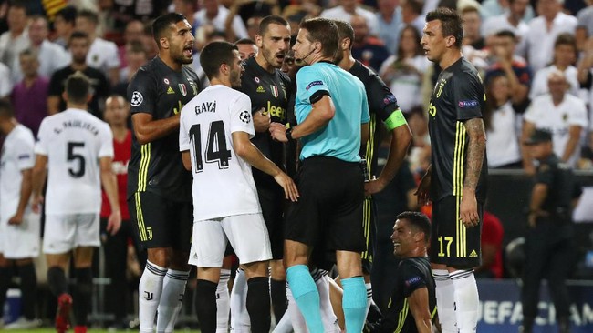 Felix Brych dikerubungi pemain Juventus usai memberi kartu merah pada Cristiano Ronaldo (Foto: REUTERS/Sergio Perez)