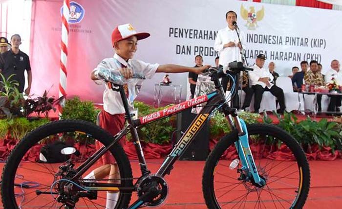 Presiden Jokowi memberi hadiah sepeda kepada seorang anak dalam suatu acara. (Foto: Dok.Antara)