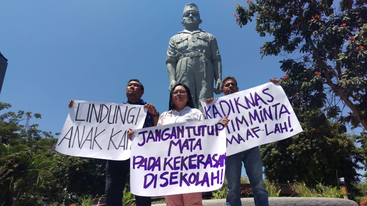 Orang tua korban saat membentangkan poster di Patung Gubernur Suryo Surabaya, Jumat 28 September 2018.