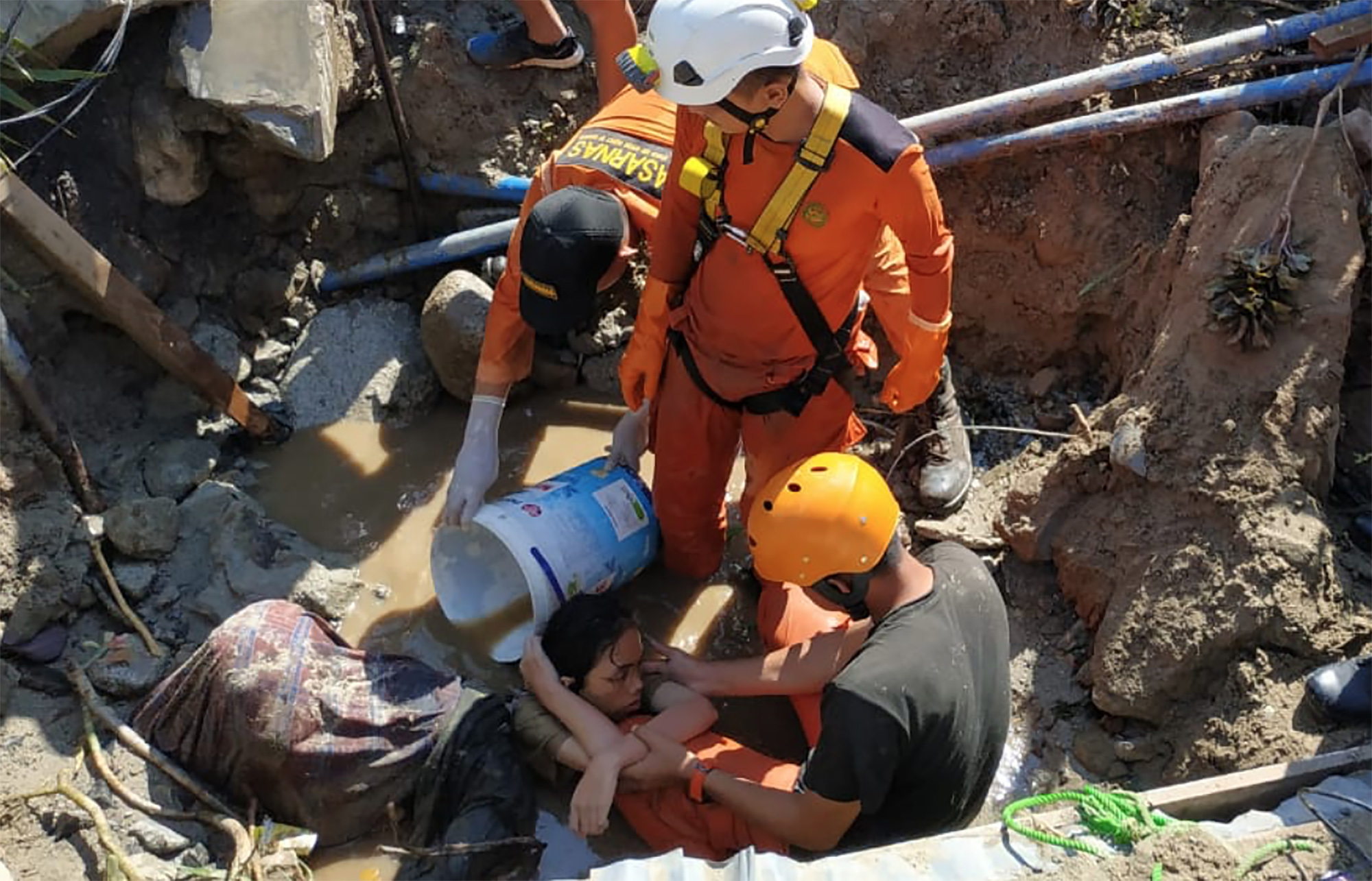 Tim SAR sedang mengevakuasi salah satu korban gempa yang tertimpa reruntuhan, Minggu, 30 September 2018. (Foto: Antara)