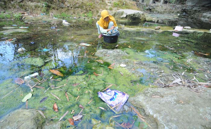 Warga mengais air bersih  di sungai Desa Blumbungan, Pamekasan, Jawa Timur, Senin 1 Oktober. Sebagian warga di Kabupaten Pamekasan kesulitan mendapatkan air bersih untuk keperluan sehari-hari karena faktor kemarau. (Foto: Saiful Bahri/Antara)