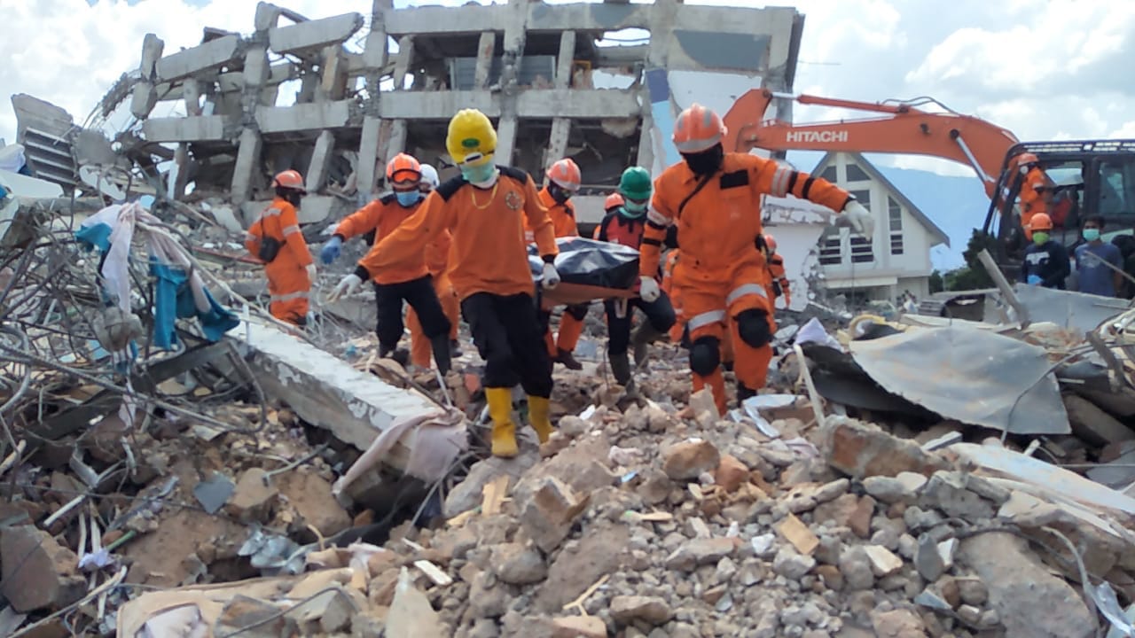 Timsar gabungan mengevakuasi jenazah yang ditemukan dari reruntuhan gempa Palu. Foto: istimewa/basarnas