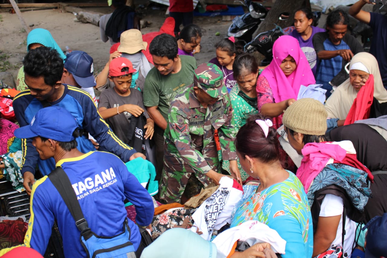 Anggota TNI membagikan bantuan berupa pakaian bekas layak pakai kepada korban bencana di Palu. (Dok. Divif 2 Kostrad)