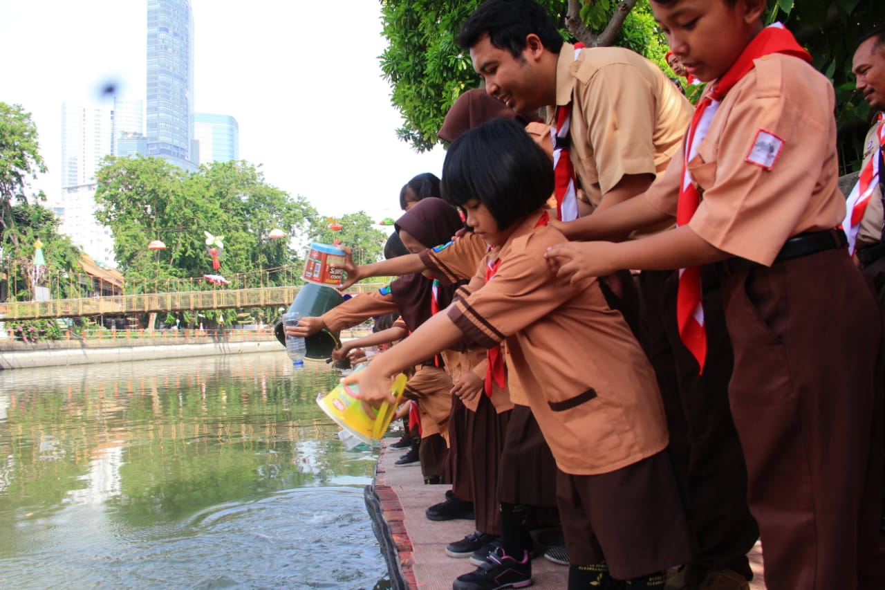Ratusan siswa SDN Kaliasin 1 Surabaya melakukan kegiatan tabur benih ikan di sungai Taman Prestasi Surabaya, Sabtu, 6 Oktober 2018.