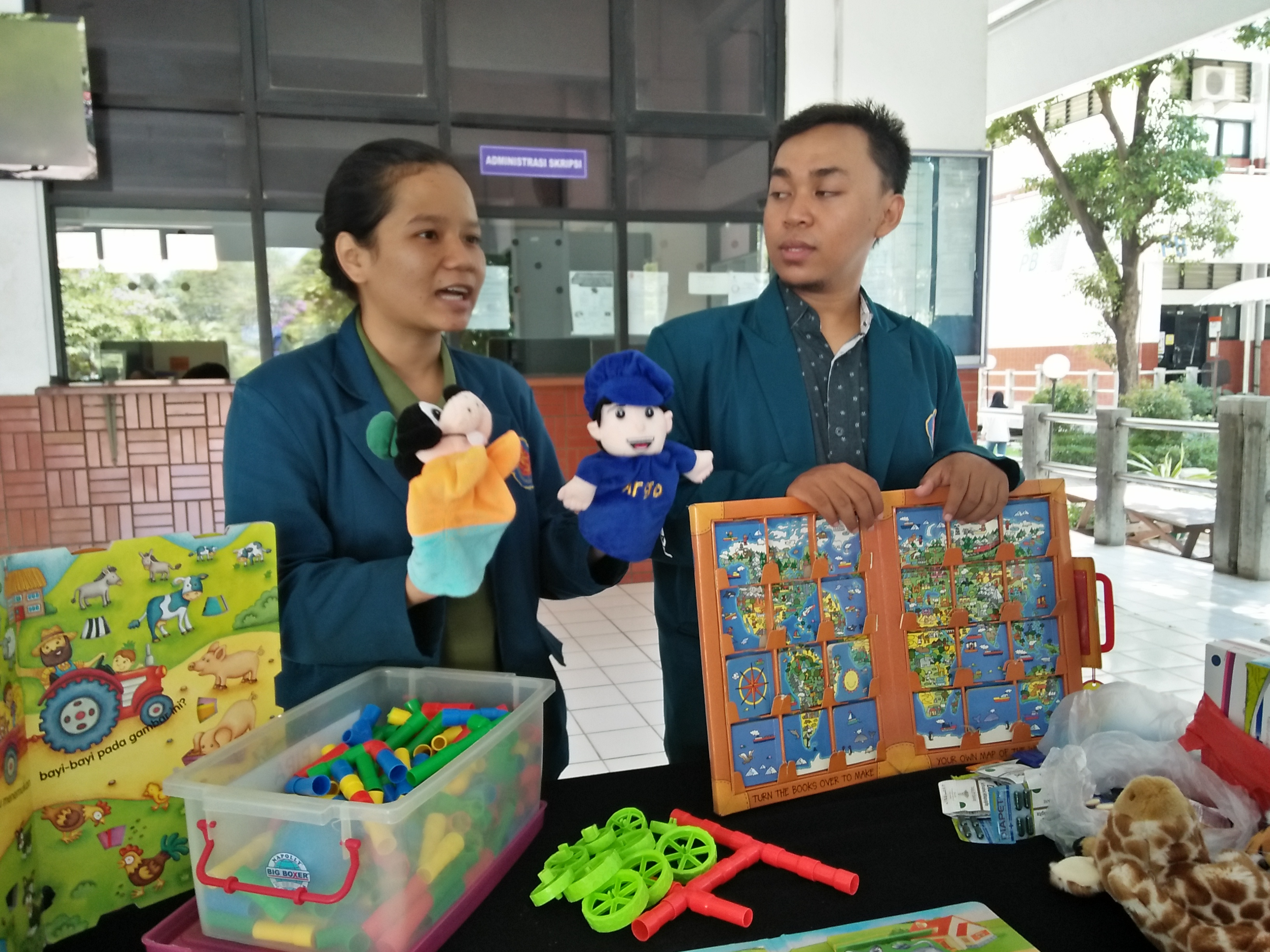 Dua mahasiswa Ubaya yang akan berangkat ke Palu mempersiapkan mainan edukasi untuk para korban. (Foto: Amanah/ngopibareng.id)