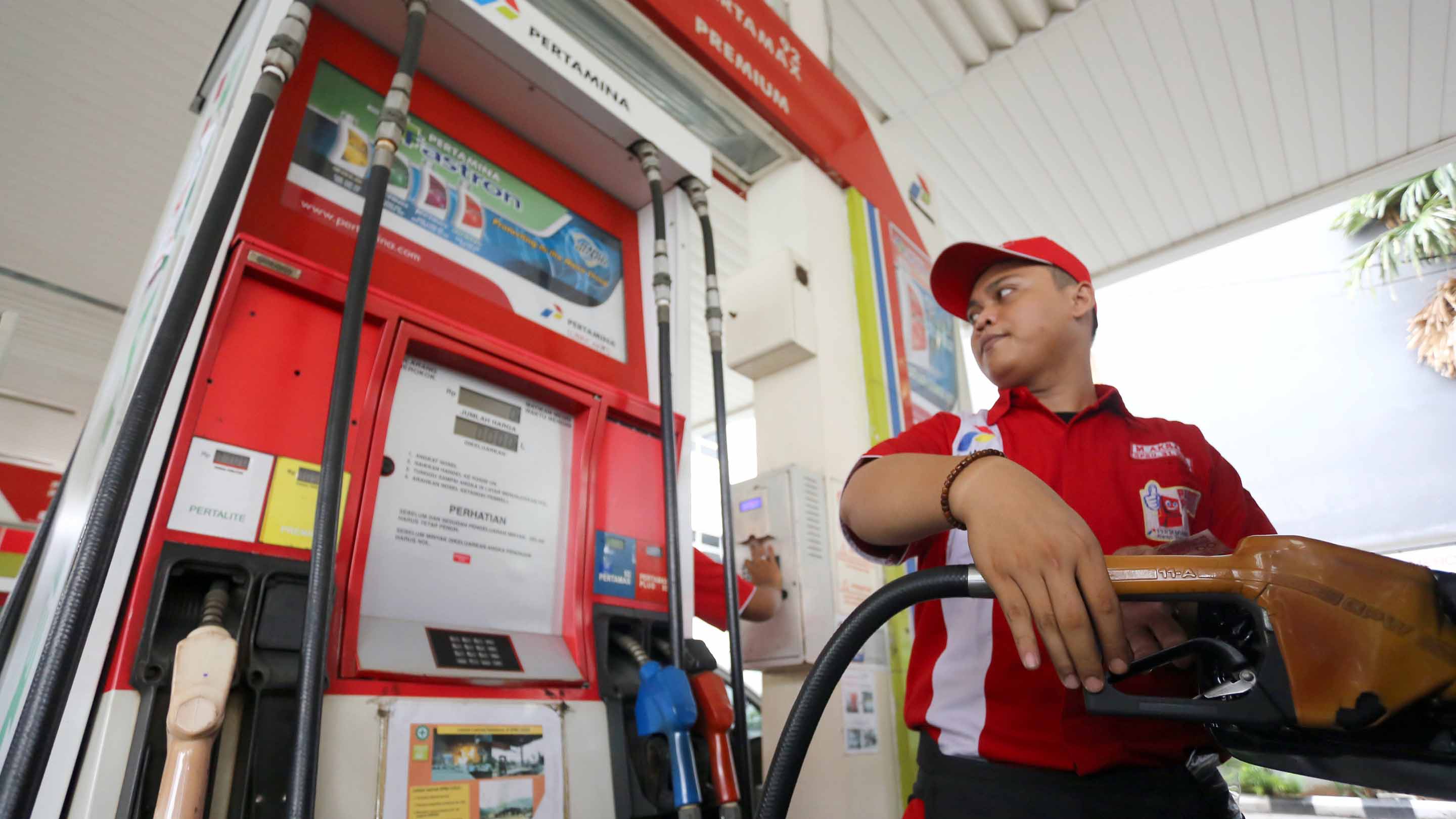 Seorang petugas SPBU tengah mengisi bahan bakar kepada konsumen. Hari ini pemerintah secara resmi menaikkan BBM jenis Premium untuk wilayah Jawa, Madura, dan Bali dari Rp6.650 menjadi Rp7.000 perliter. 