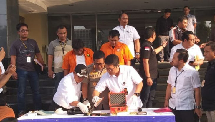 Dua tersangka IAW dan RMY (baju oranye) merupakan pegawai negeri sipil Kementerian Perhubungan yang terkait penembakan peluru nyasar pada dua ruangan anggota DPR RI saat dirilis di Polda Metro Jaya, Selasa (16 Oktober 2018. (Foto: Antara/Taufik Ridwan)