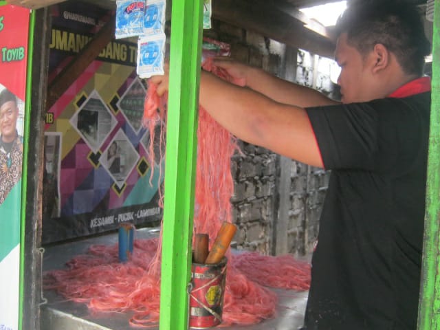 Seorang pekerja sedang mengolah adonan Harum Manis. (Foto: Totok/ngopibareng.id)