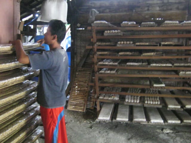 Salah satu pengrajin tempe di Lamongan, Sutadi sedang menata tempe hasil produksinya. (Foto: Totok/ngopibareng.id)