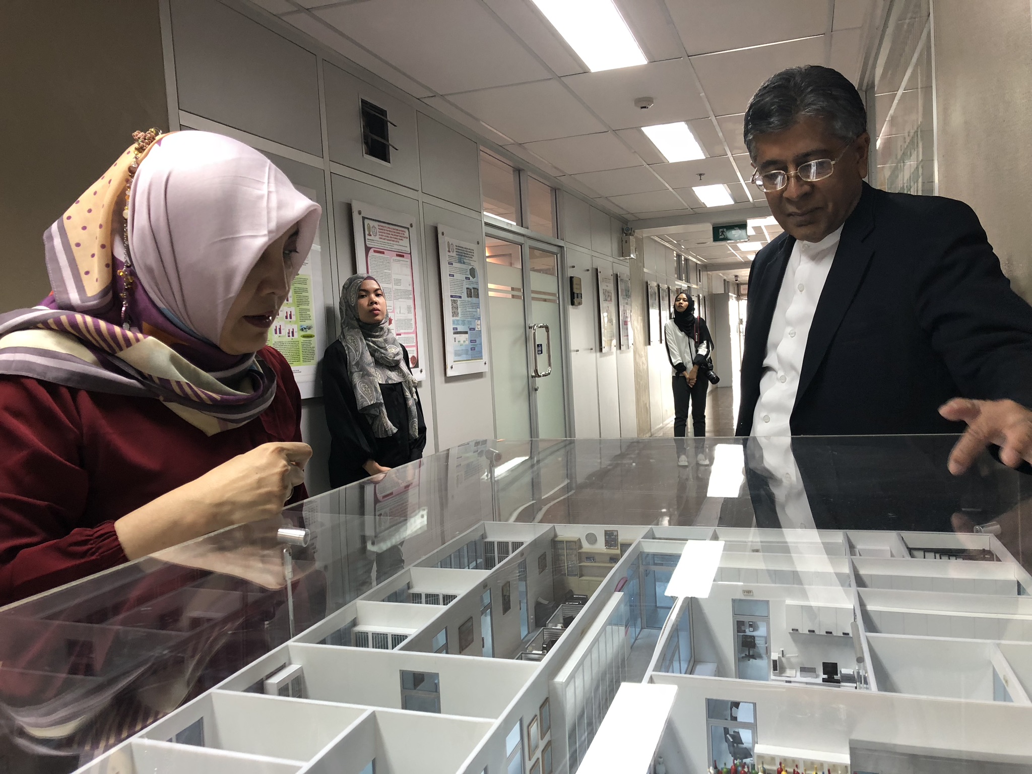 Manat Suebsantikul menjelaskan maket lab the halal science center kepada tamunya. (Arif Afandi/ngopibareng.id)