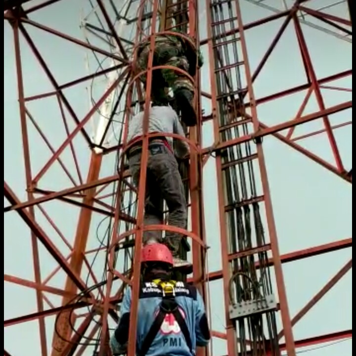 Tim penyelamat mencoba menurunkan Osep dari tower. (Foto: Umar/ngopibareng.id)