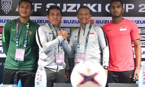 Pelatih Timnas Indonesia, Bima Sakti dan Pelatih Singapura Fandi Ahmad berjabat tangan usai sesi jumpa pers Piala AFF 2018. (Foto: pssi.org) 