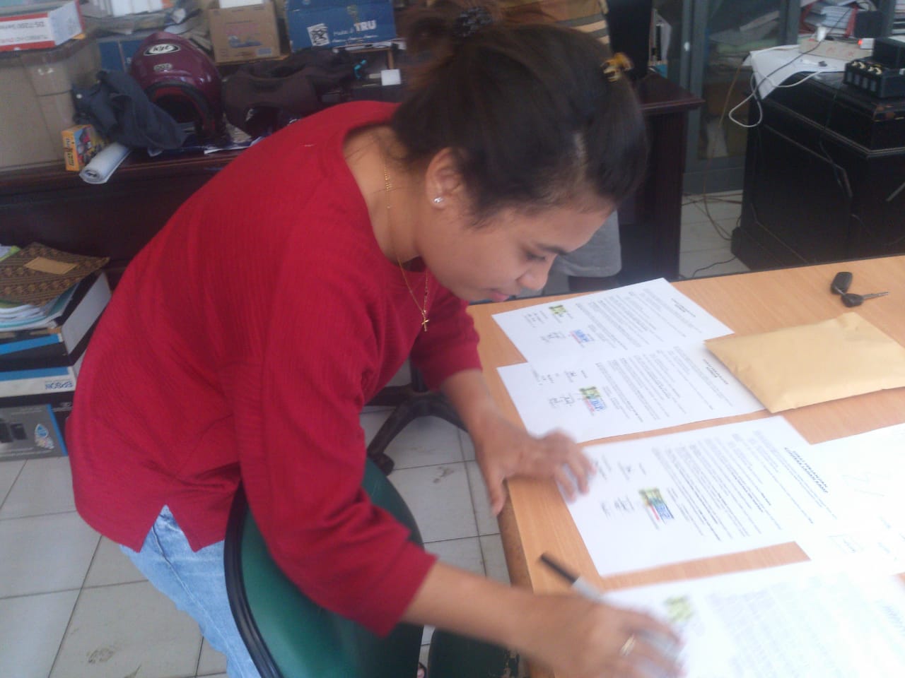 Warga dari Distrik Tanah Rubuh membubuhkan tanda tangan persetujuan tanah adat yang dipakai dalam penanganan longsor di ruas Maruni-Oransbari Km50. (Foto: Endra.ngopibareng.id)