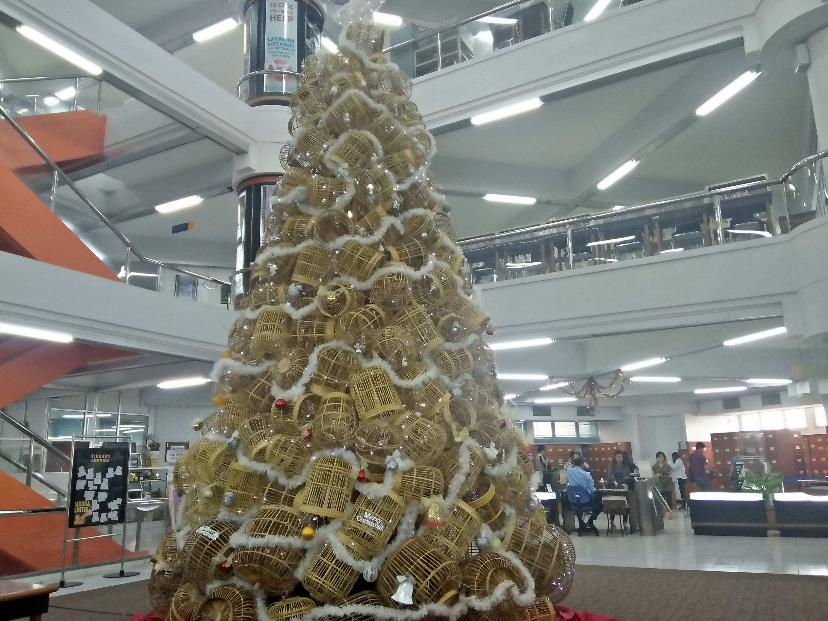 Pohon Natal yang terbuat dari kurungan berdiri kokoh di ruang pamer Perpustakaan UK Petra Surabaya. (Foto: Amanah/ngopibareng.id)