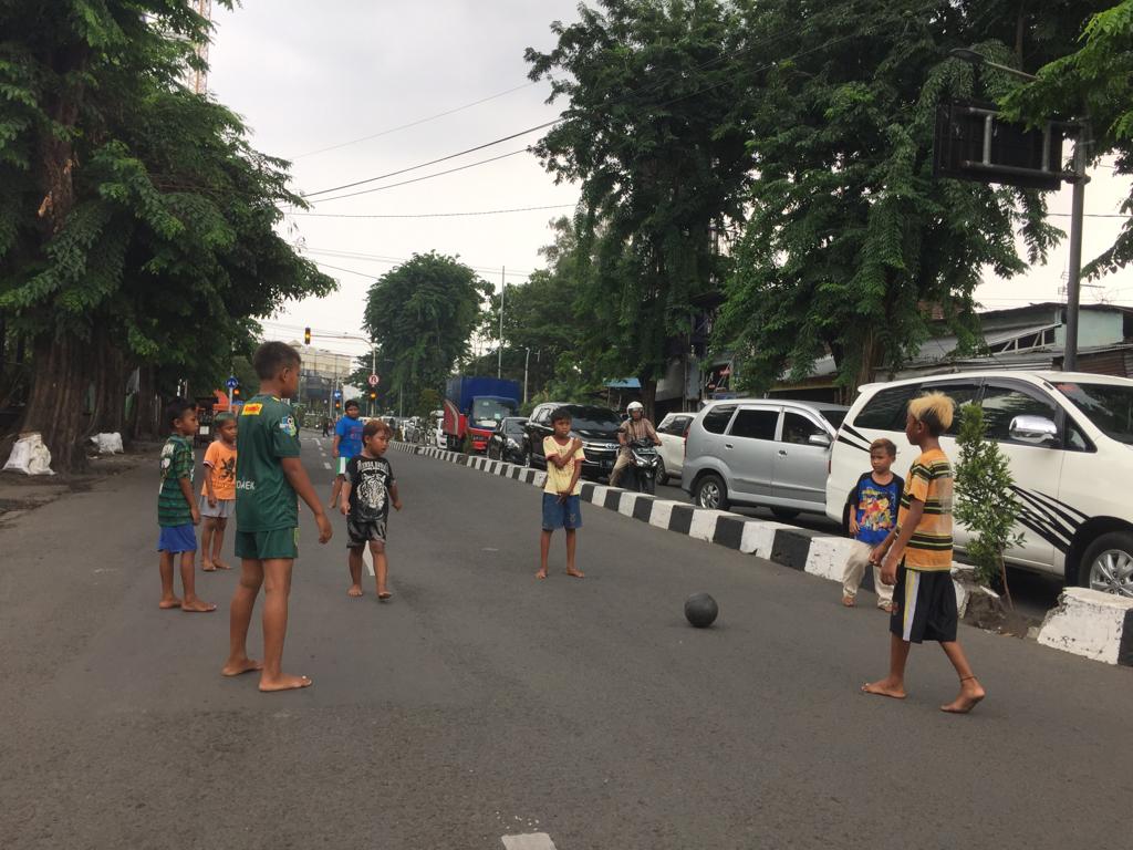 Delapan anak asik bermain sepak bola di Jalan Sulawesi. (Foto: Amanah/ngopibareng.id)