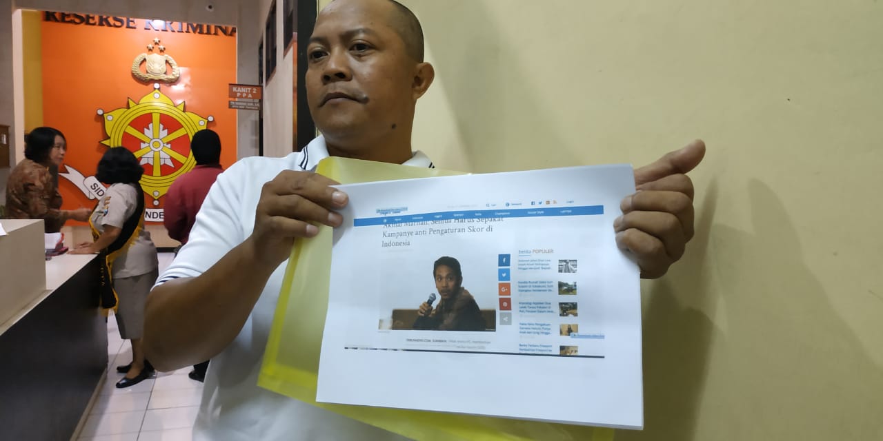 Achmad Gozali menunjukkan barang bukti saat pengaduan di Polres Malang Kota.