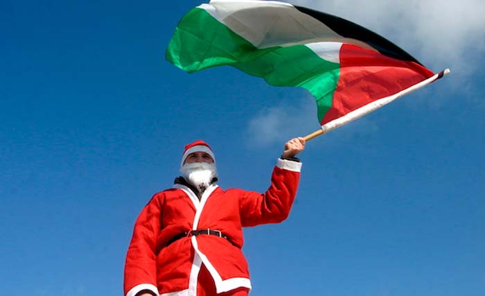 Sinterklas Palestina mengibarkan bendera negaranya, di Tepi Barat. (Foto: AFP)