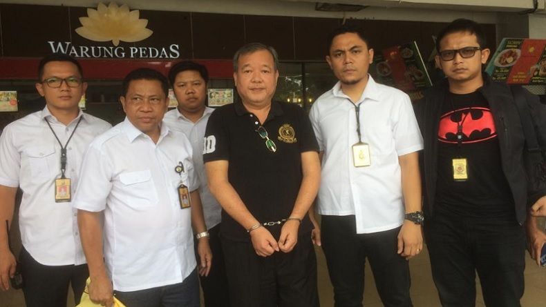 Anggota Komite Eksekutif PSSI, Johar Lin Eng langsung diborgol usai ditangkap di Bandara Halim Perdana Kusuma, Kamis, 27 Desember 2018. (Foto: Antara)