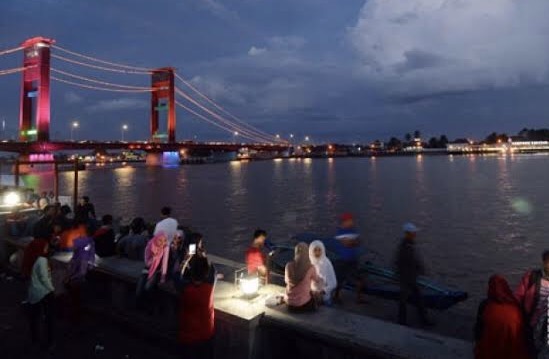 Warga menikmati keindahan malam di Jembatan Ampera. Foto: Antara
