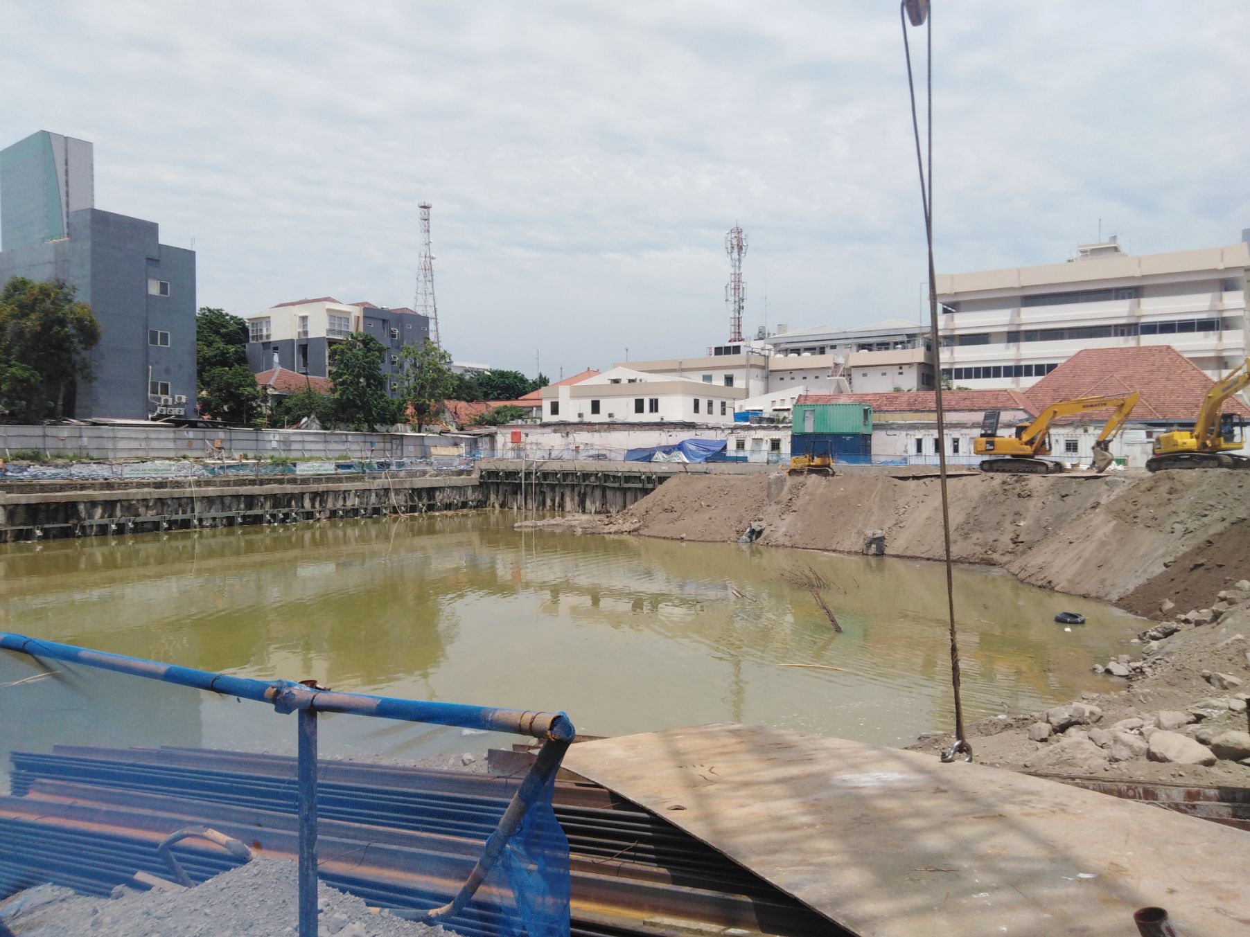 Kondisi lubang basement di Jalan Raya Gubeng, nampak terdapat sirtu dan genangan air tanah yang sengaja dibiarkan, Senin 31 Desember 2018. (foto: farid/ngopibareng.id) 
