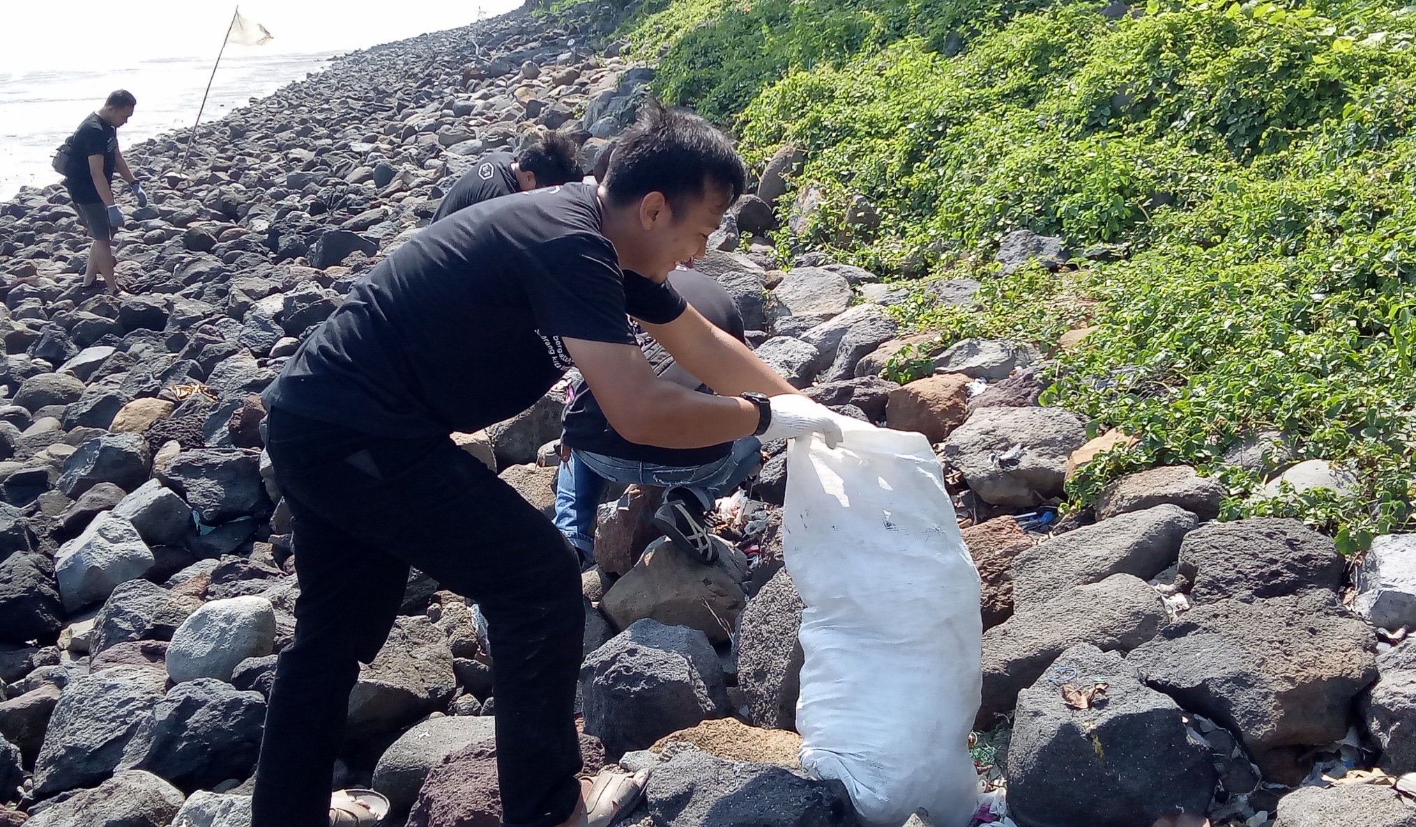 Aksi resik-resik pantai Kenjeran. Batu-batu disweping untuk mencari sembunyinya sampah. Aksi digelar 6 Desember 2019. (Foto:Pitasari)