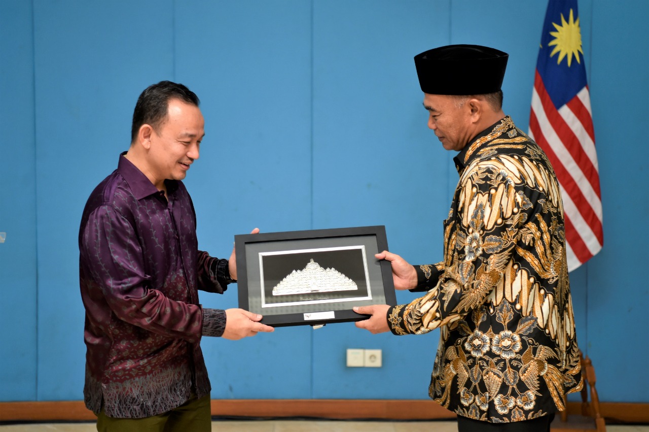 Mendikbud Muhadjir Effendy menyerahkan cindera mata kepada Menteri Pendidikan Malaysia Mazslee bin Malik. (Foto: Asmanu/ngopibareng.id).