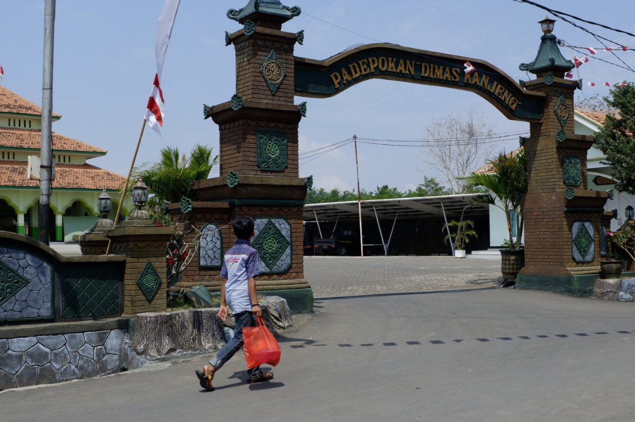 Seorang bocah melintasi pintu gerbang di Padepokan Dimas Kanjeng Taat Pribadi. (Foto: Ikhsan/ngopibareng.id)