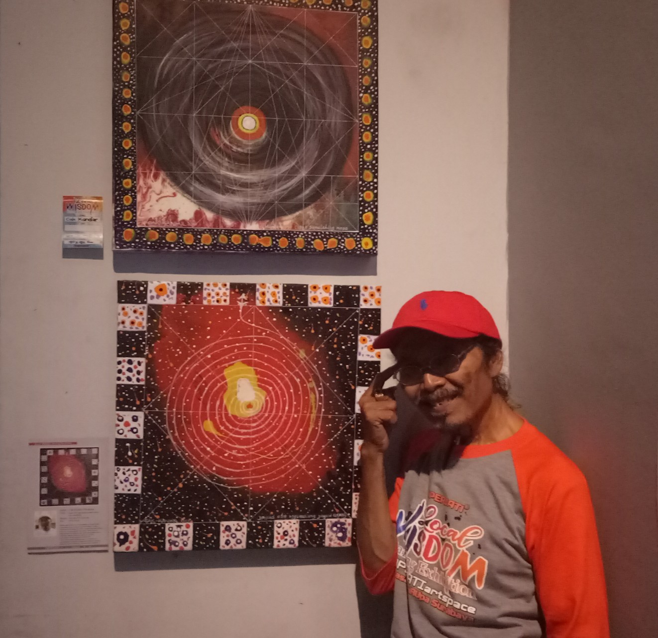 Cak Kandar bersama karya lukisannya yang dipamerkan di acara Pameran Lukisan Koperjati, Surabaya, Minggu, 20 Januari 2019. (Foto: Pita/ngopibareng.id)