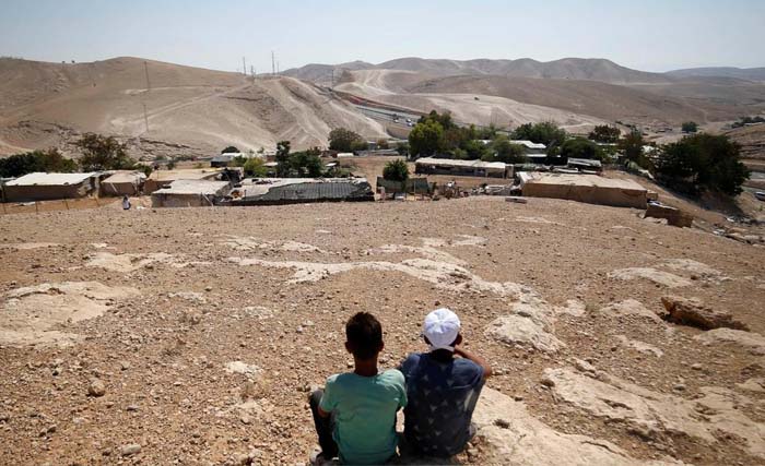 Dua anak Palestina sedang menatap desanya di kawasan Khan al-Ahmar, yang akan dihancurkan oleh Israel sebagai temp[at permukiman baru. (Foto:VOT Cape)