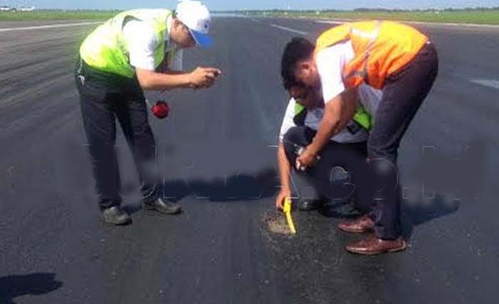 Petugas memeriksa kondisi landasan pacu Bandara Juanda, hari Kamis. (Foto:Surya.c.id)
