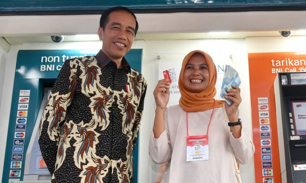 Presiden Jokowi menyaksikan peserta program keluarga harapan (PKH) menarik uangnya di medin ATM. (Foto: Asmanu/ngopibareng.id)