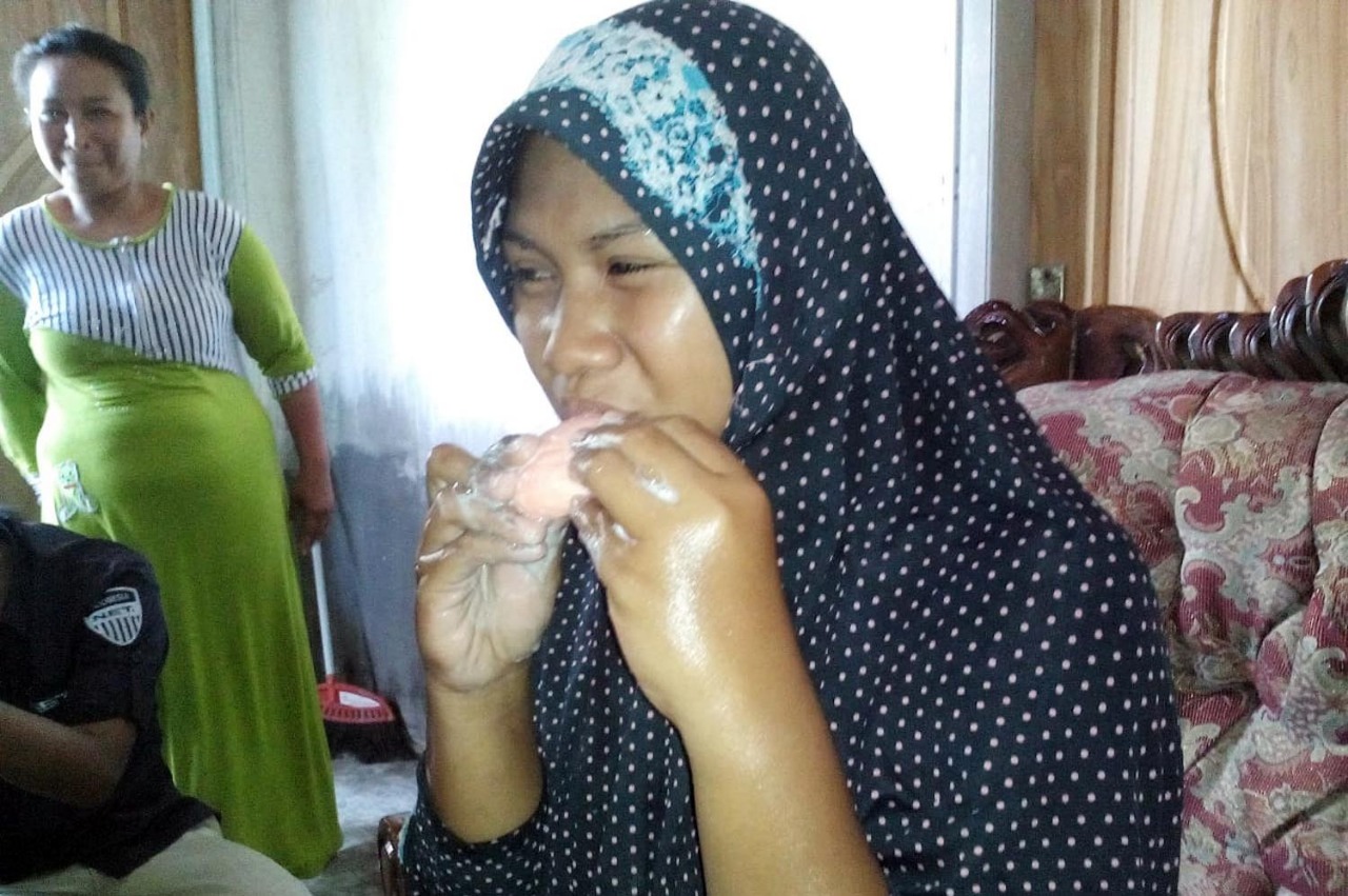 Khosik, perempuan asal Desa Dungun, Kecamatan Tongas, Kabupaten Probolinggo saat makan sabun mandi. (Foto: Ikhsan/ngopibareng.id).