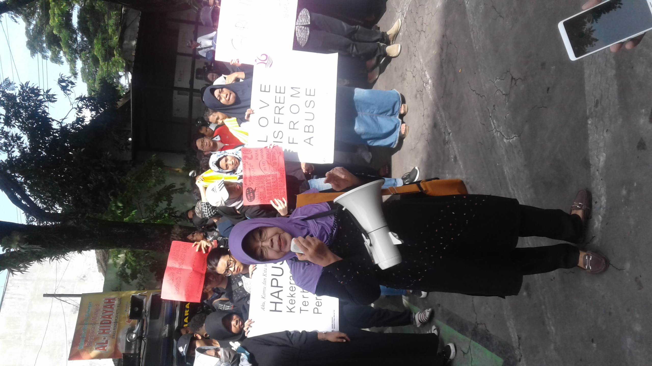 Puluhan peserta aksi berdiri di depan kantor Dinas Pendidikan Kota Malang (Foto: Fajar/ngopibareng.id)