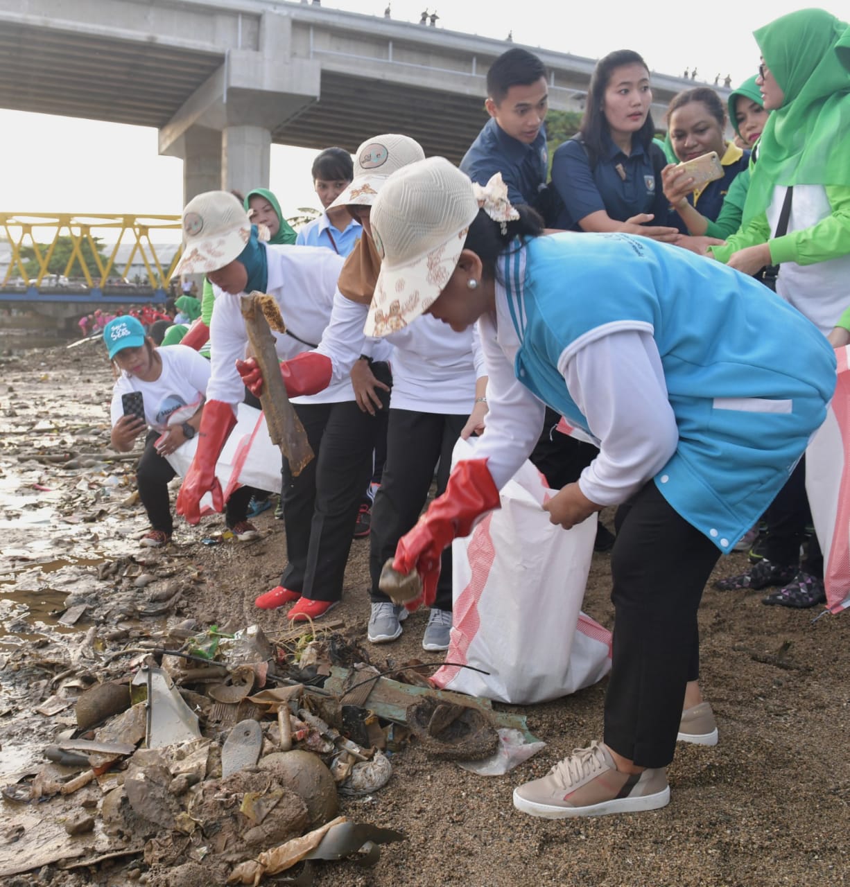 Ibu Negara Iriana Joko Widodo bersama anggota  OASE-KK  punguti sampah di Pantai Galala. (Foto: Biro Pers Setpres)