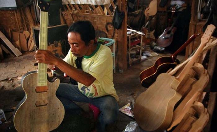 Seorang pengrajin gitar menyelesaikan proses pembuatan gitar di industi gitar rumahan "Sianturi Gitar", Pugeran, Maguwoharjo, Depok, Sleman, Yogyakarta. (Foto:Antara)