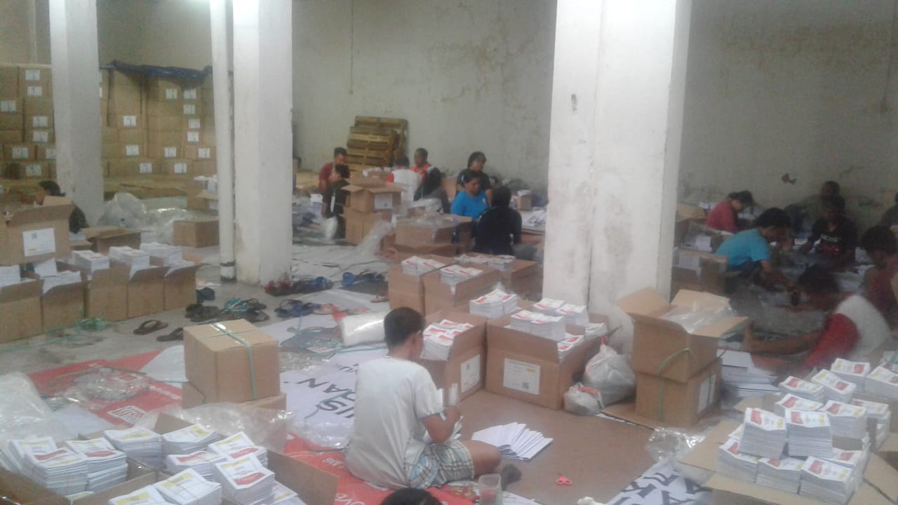 Puluhan orang melipat kertas suara di gudang logistik KPU Kota Malang (Foto: Fajar/Ngopibareng.id)