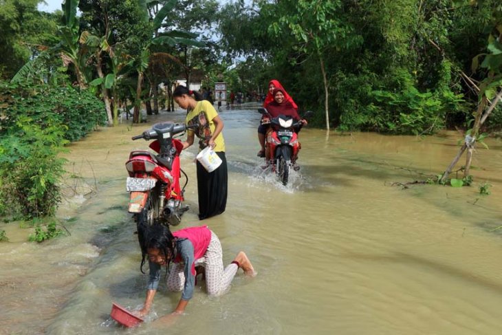 Sejumlah warga di Desa Guyangan, Kecamatan Trucuk, Bojonegoro, di lokasi genangan banjir luapan Bengawan Solo. (Foto: Antara/Slamet Agus Sudarmojo.)