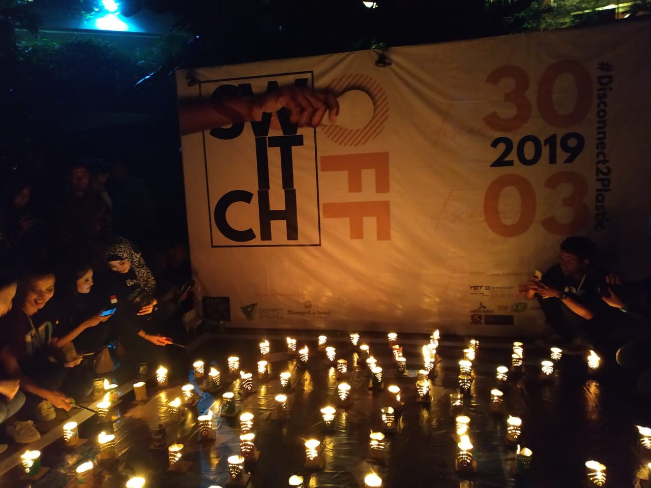Pengiat Earth Hour di Surabaya saat menyalakan lilindi area kolam renang hotel Shangri-la. Sabtu, 30 Maret 2019. (Foto: istimewa) 