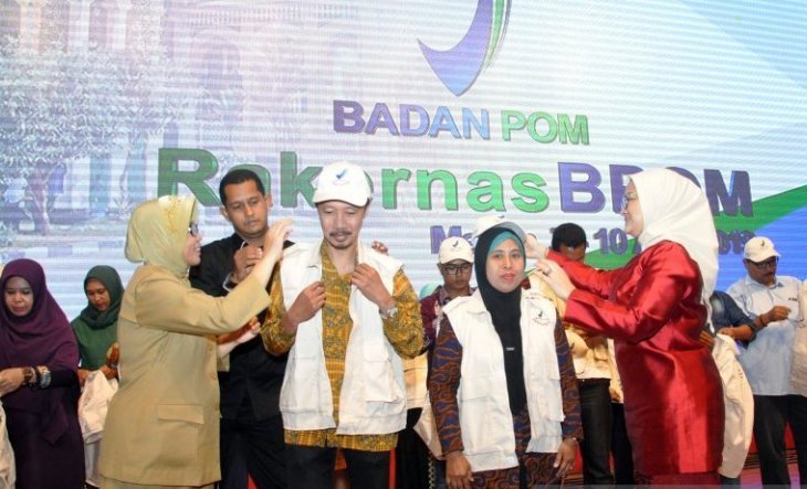 Kepala BPOM Penny K Lukito (kanan) bersama Sekda Sumut Sabrina (kiri) memakaikan seragam fasilitator kepada masyarakat binaan BPOM pada kegiatan Rapat Kerja Nasional (Rakernas) Badan POM 2019 di Medan, Sumatera Utara, Senin (8/4/2019). (Antara Sumut/Septianda)