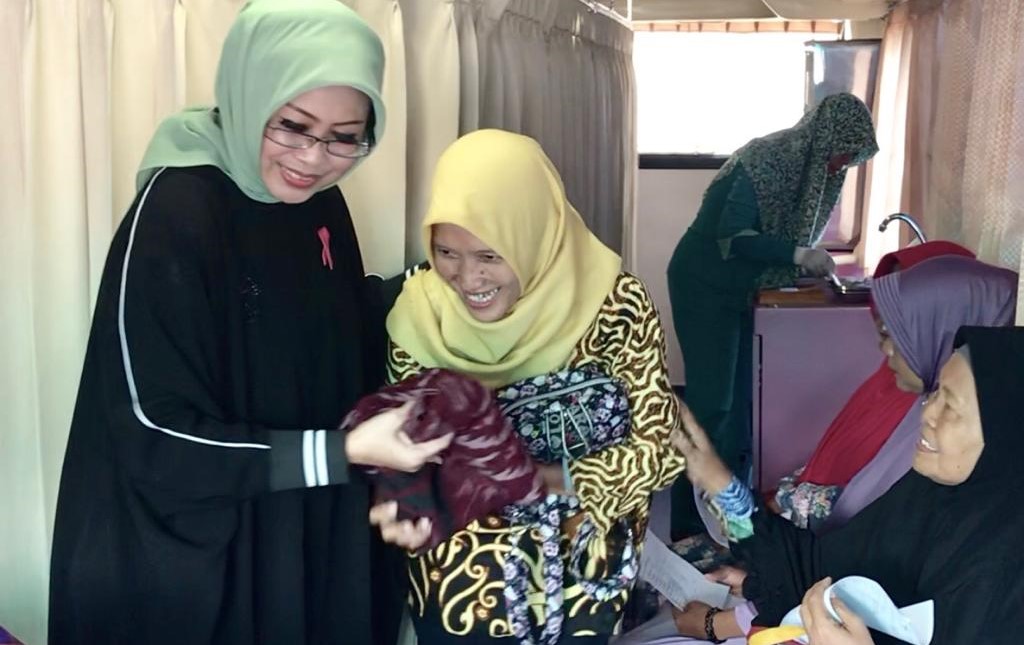 Pendiri Yayasan Citra Fatma Wanita, Fatma Saifullah Yusuf membantu seorang ibu nelayan yang akan melakukan pemeriksaan di dalam Bus Fatma Foundation, Kamis, 11 April 2019. (Foto: dok/fatma foundation)