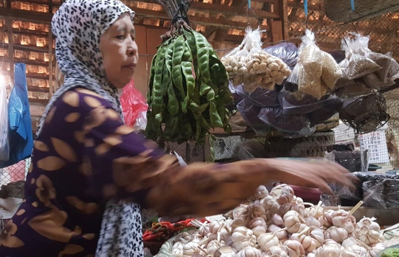 SEORANG pedagang bawang putih di Pasar Baru, Kota Probolinggo. (Foto: Ikhsan/ngopibareng.id).
