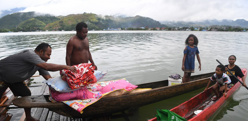 Warga mengamankan barang berharga miliknya dari rumahnya yang dilanda banjir bandang di kawasan Danau Sentani, Sentani, Jayapura, Papua, Selasa 19 Maret 2019 (Foto: Antara/Zabur Karuru)