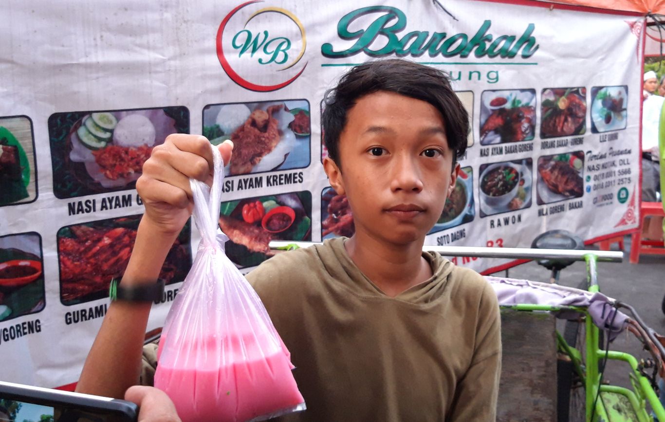 Salah satu pembeli Es Permen Karet di Kawasan Ampel, Surabaya.  (Foto: Haris/ngopibareng.id)
